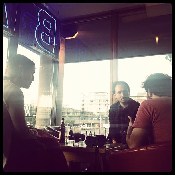 Three people at a lunch table by a waterfront window.